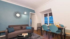 Un salon comprenant un canapé, une table basse et un coin repas avec des chaises et une table.