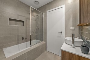 Enjoy a refreshing shower or soak in the separate bathtub with seat.
