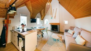 Un espace de vie chaleureux de style loft, comprenant une cuisine, un coin repas et un salon.