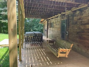 Enjoy the outdoors from the elevated porch with a wooden bench and table.