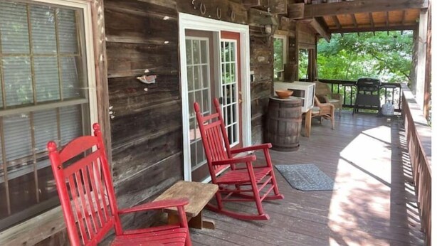 A wooden cabin with a porch, rocking chairs, and a table. - Hilltop Hideaway in the Nacoochee Village (Helen)