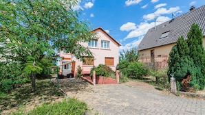 A residential area with a paved driveway leading to a house with a red door and a small porch. - L'Adeline - Charmant appartement (Lingolsheim)