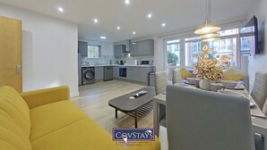 A modern apartment with a living room, dining area, and kitchen. - Beauchamp House (Coventry)