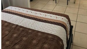 A hotel room with a bed, a desk, a chair, a television, and a heater. - A 10 min de la Garita de San Ysidro/zona Río (Tijuana)