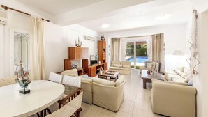 A spacious living area with a pool, a dining table, and a seating arrangement. - Protaras Apollon Seaside Villa (Protaras)