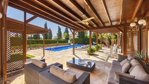 A covered outdoor area with a pool, lounge chairs, and a pergola. - Protaras Apollon Seaside Villa (Protaras)