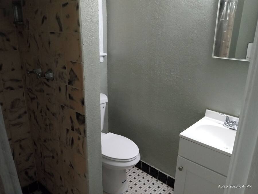 Une salle de bain équipée de toilettes, d’un lavabo et d’un miroir.