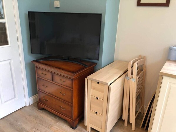 A room with a wooden dresser, a television, and a light-colored desk with drawers. - The Annex - Modern Studio Flat (Mold)