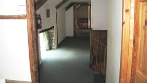 A narrow hallway with wooden beams, a stone wall, and a door leading to another room. - Beautiful Large Rural Cottage Near Pencader (Pencader)
