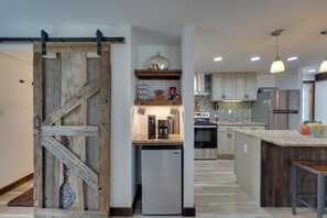 Una cocina con puerta de madera, electrodomésticos de acero inoxidable y encimera de granito.