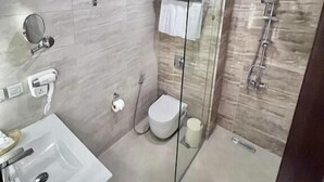A modern bathroom with a glass shower enclosure, a toilet, and a sink. - Petra Icon Hotel (Wadi Musa)