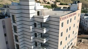 A multi-story hotel with a modern design, featuring balconies on each floor. - Petra Icon Hotel (Wadi Musa)