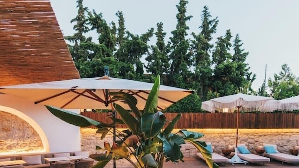 A poolside area with lounge chairs, tables, and umbrellas. - Rupa Experience Alacati (Cesme)