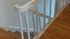 Una escalera de madera con barandillas blancas y piso de madera.