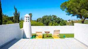 A rooftop terrace with two sun loungers, a small table, and a decorative white structure. - Xodo - CHARMING AND SECLUDED THREE-BEDROOM VILLA (Carvoeiro)
