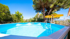 A swimming pool with a ladder, surrounded by trees and a clear sky. - Xodo - CHARMING AND SECLUDED THREE-BEDROOM VILLA (Carvoeiro)