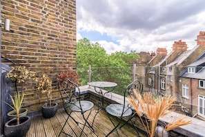 Relax in a tranquil outdoor space with a brick wall, wooden deck, and potted plants.