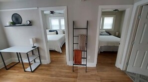 2 habitaciones, escritorio y tabla de planchar con plancha
