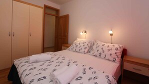Ein Schlafzimmer mit einem Bett, einem Kleiderschrank und zwei Nachttischlampen.