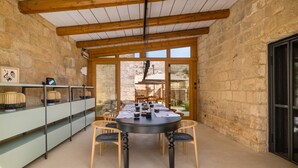 A dining area with a round table, chairs, and a glass cabinet with decorative items. - I Tre Bacili (Spongano)