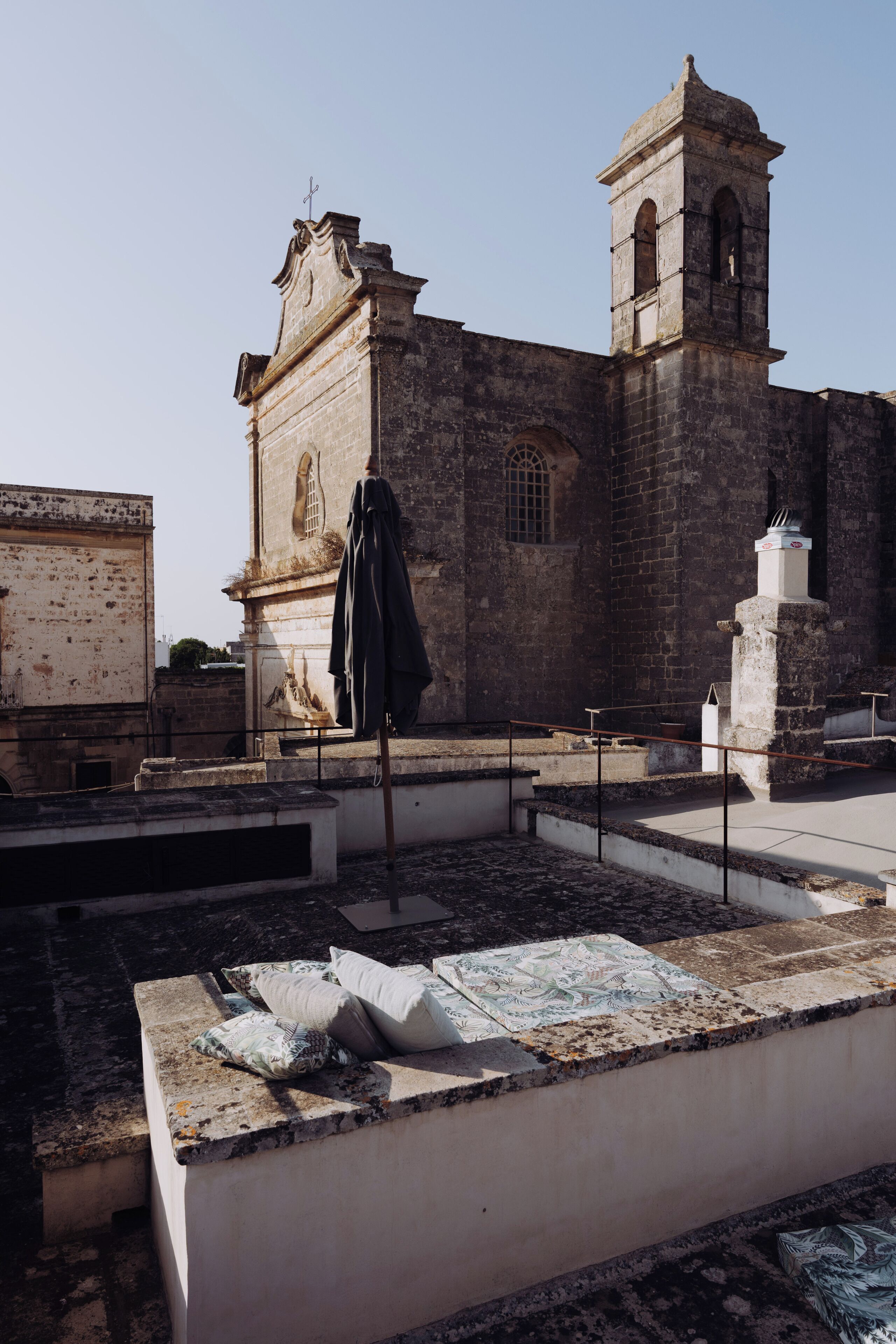 Un edificio histórico con una torre de campanas y una estatua en su fachada.
