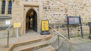 A stone building entrance with a sign indicating admission price. - Hepple Hill Cottage (Consett)