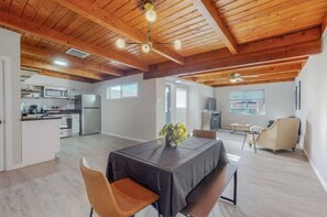 Spacious living area with a high ceiling and dining table, surrounded by comfortable chairs.