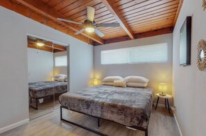 Cozy retreat with a large bed, bedside tables, and a large mirror.
