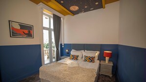 A bedroom with a bed, a nightstand, a lamp, a window with curtains, and a wall painting. - Maria Luisa by INTROVERT HOTELS (Sofia)