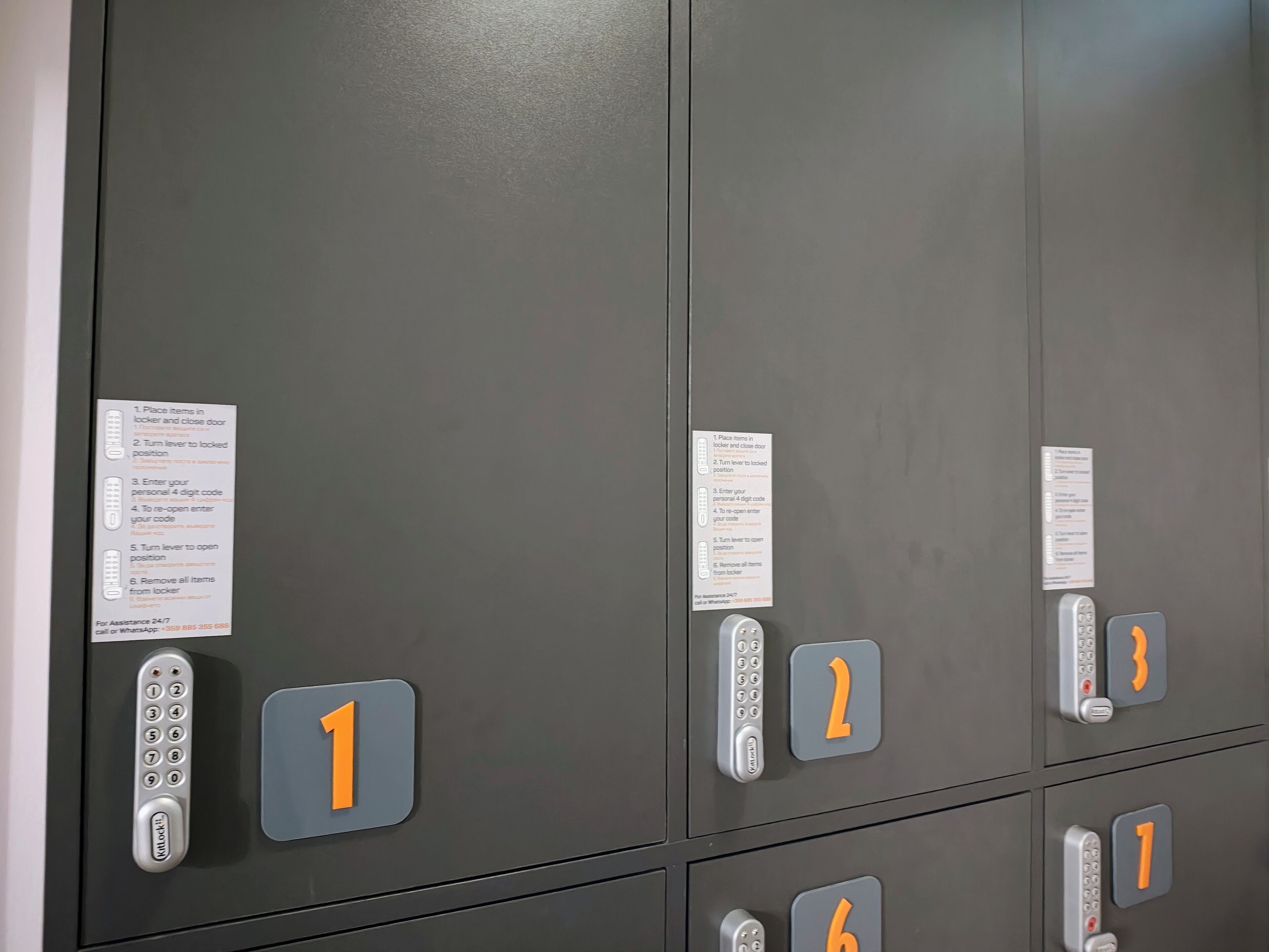 A row of elevator doors with numbered locks and instructions for use.