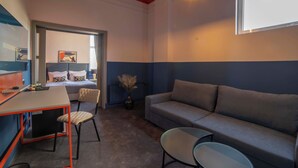 A hotel room with a bed, a sofa, a desk with a chair, and a small table. - Maria Luisa by INTROVERT HOTELS (Sofia)