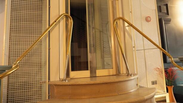 A set of beige, curved stairs with a glass door at the top, leading to an interior space. - Maria Luisa by INTROVERT HOTELS (Sofia)