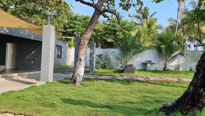 A modern house with a well-maintained lawn, a concrete pathway, and a hammock. - Casa de Playa con Mini Golf (La Libertad Department)