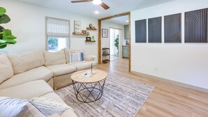 A modern living room with a beige sofa, a round coffee table, and a ceiling fan. - Pet-Friendly Alabama Retreat w/ Deck & Patio! (Moody)