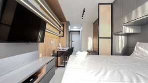A modern hotel room with a flat-screen TV, a desk with a chair, a bed with white linens, and a large window. - MichiH - Perfeito Studio em Pinheiros (São Paulo)