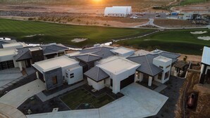 A modern residential development with multiple houses featuring flat roofs and a central community building.
