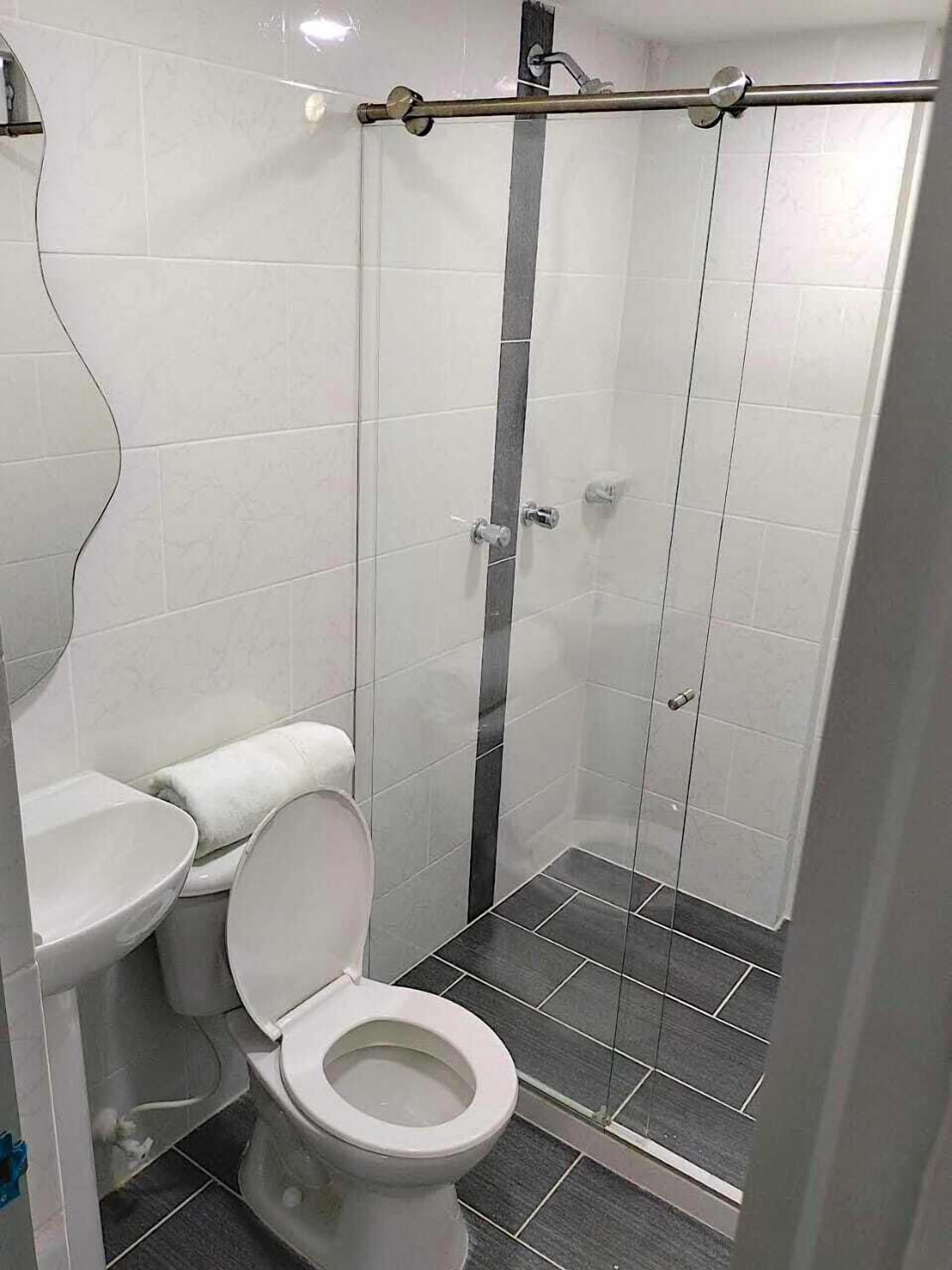 A bathroom with a toilet, a bidet, and a shower stall.
