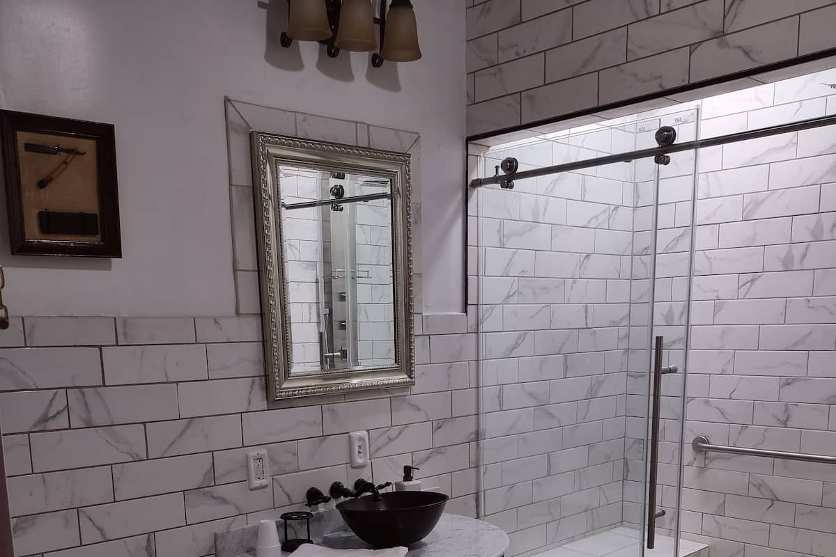 Une salle de bain équipée de toilettes, d’un lavabo et d’une douche à parois de verre.