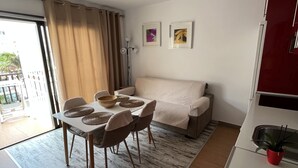 A modern living space with a dining area, a sofa, and a kitchen. - Mare Verde A10 (Costa Adeje)