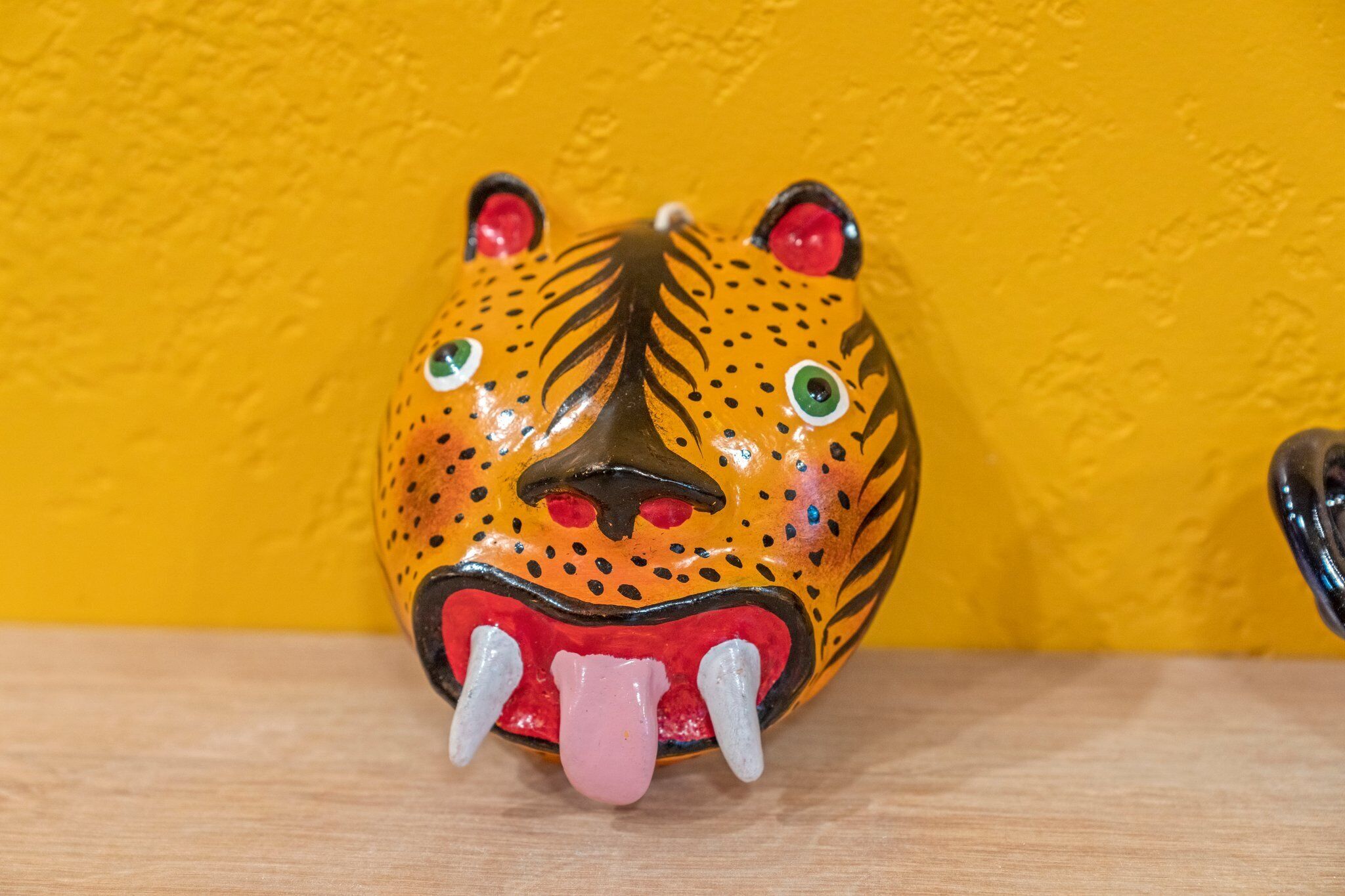 A ceramic tiger head with a yellow background.