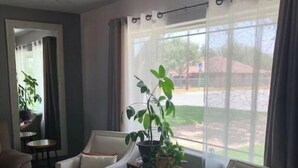 A living room with two armchairs, a coffee table, and a potted plant. - Casa Padre, Perfect for long term stays. (Weslaco)