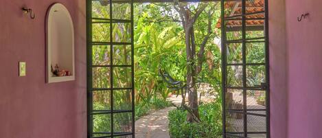 A doorway leading to a garden with a tiled floor and a tiled ceiling.