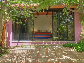 Une chambre avec un lit, une fenêtre et une vue sur la verdure.