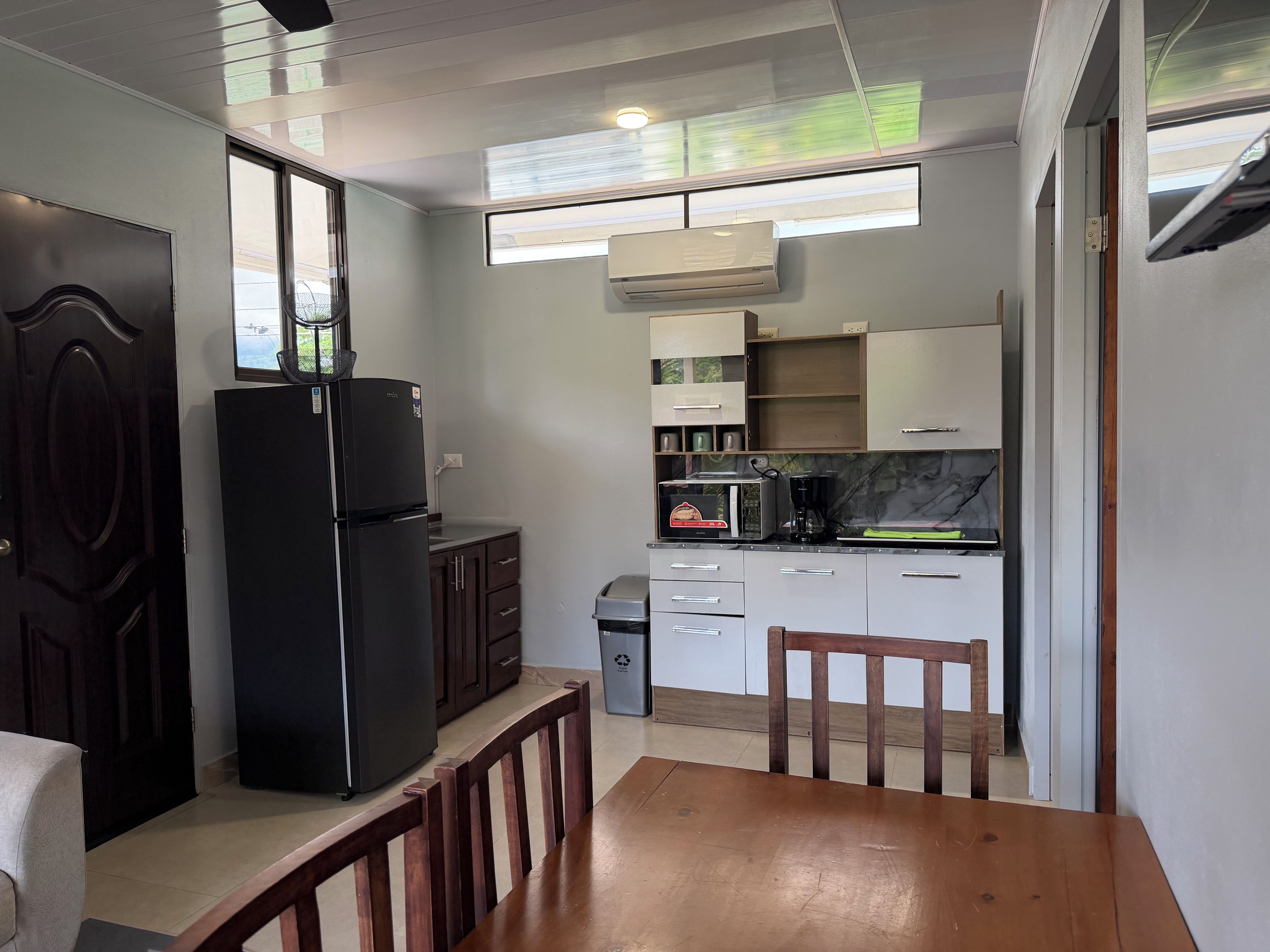 A compact kitchen with a refrigerator, microwave, and coffee maker.