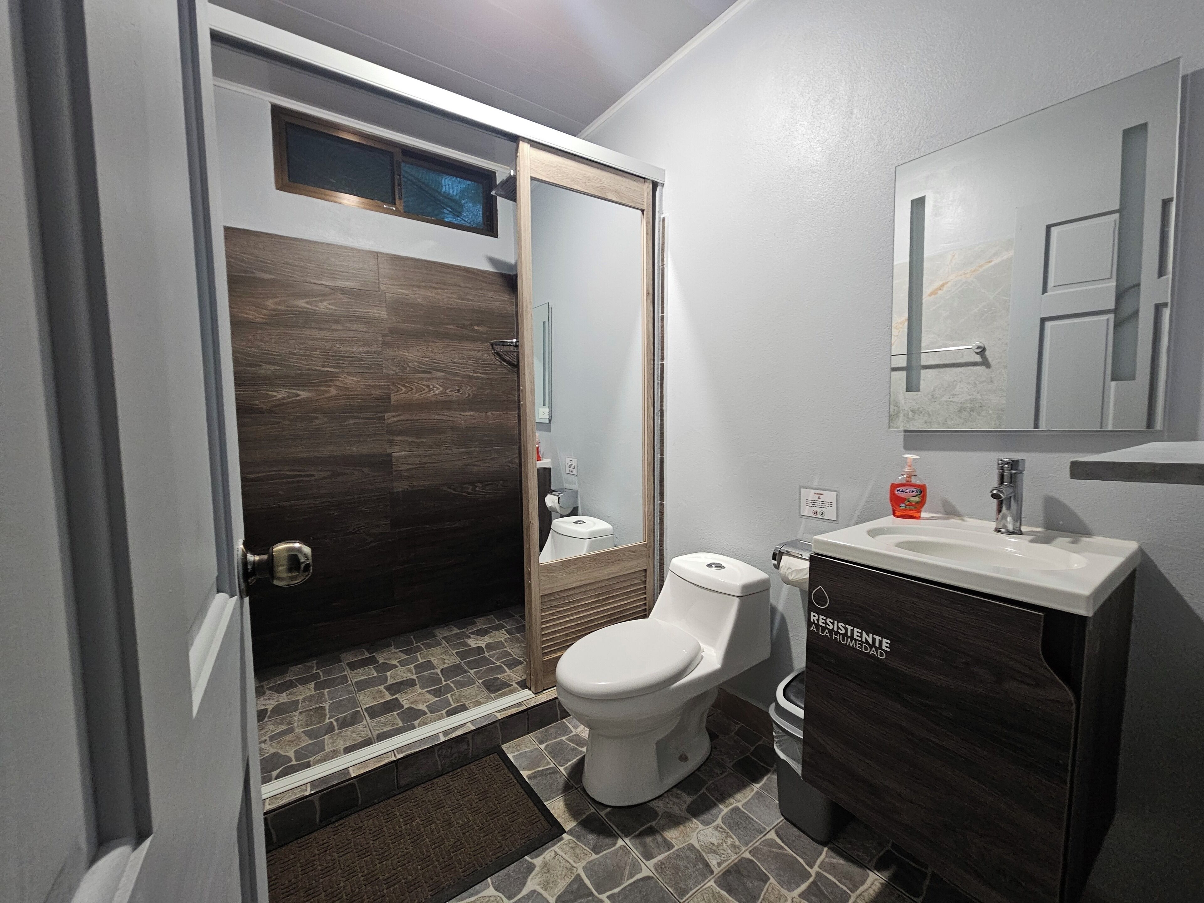 Un bagno moderno con doccia, WC e lavandino.