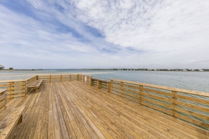 A wooden pier extending over calm water with a clear sky above.