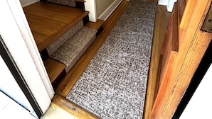 A staircase with a carpeted landing and wooden steps leading to a second floor. - "The Owl's Nest" Updated Craftsman home overlooking Old Town Park. (Westerville)