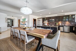 A modern kitchen with dark cabinets, stainless steel appliances, and a large island. - Medano Beach, Ocean View, Downtown, 3BD, 6th floor (Cabo San Lucas)