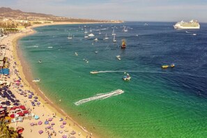 A beach with clear turquoise water, a cruise ship in the distance, and numerous sailboats. - Medano Beach, Ocean View, Downtown, 3BD, 6th floor (Cabo San Lucas)