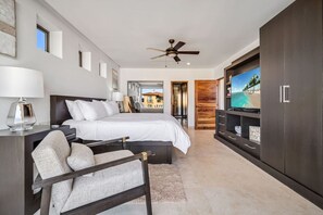 A modern bedroom with a large bed, a TV, and a wardrobe. - Medano Beach, Ocean View, Downtown, 3BD, 6th floor (Cabo San Lucas)
